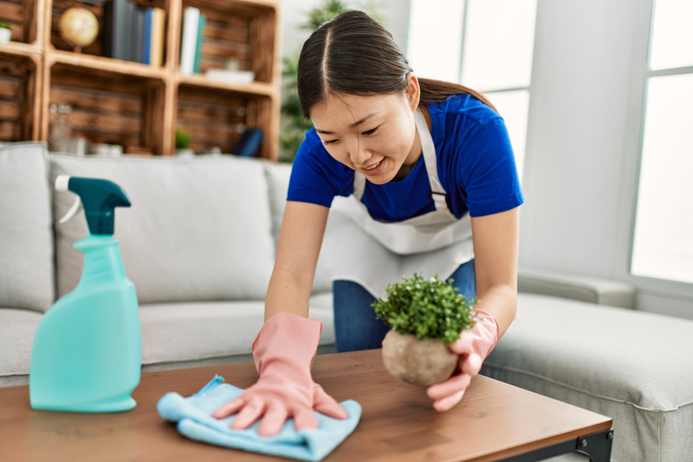 Professional cleaner wiping a table in Dubai, showcasing home cleaning services in the city.