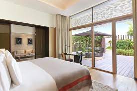 A bright 4BHK villa bedroom with modern furnishings and a scenic outdoor view showcases a pristine living space after deep cleaning in Dubai.