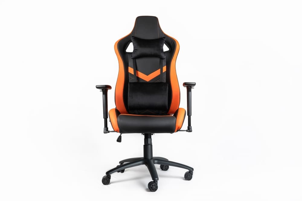 A sleek gaming chair with black and orange faux leather, featuring adjustable armrests and a high back with a racing-style design, set against a white background.
