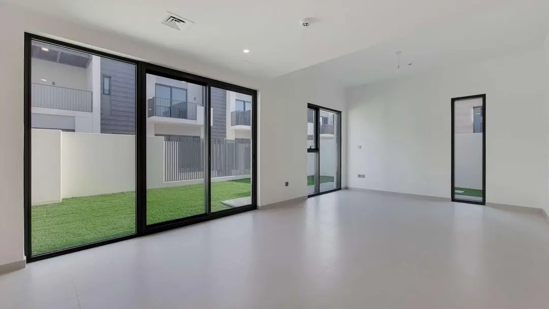 Clean and spacious 3BHK unfurnished villa with large glass windows and a backyard view, highlighting a professional deep cleaning service in Dubai.